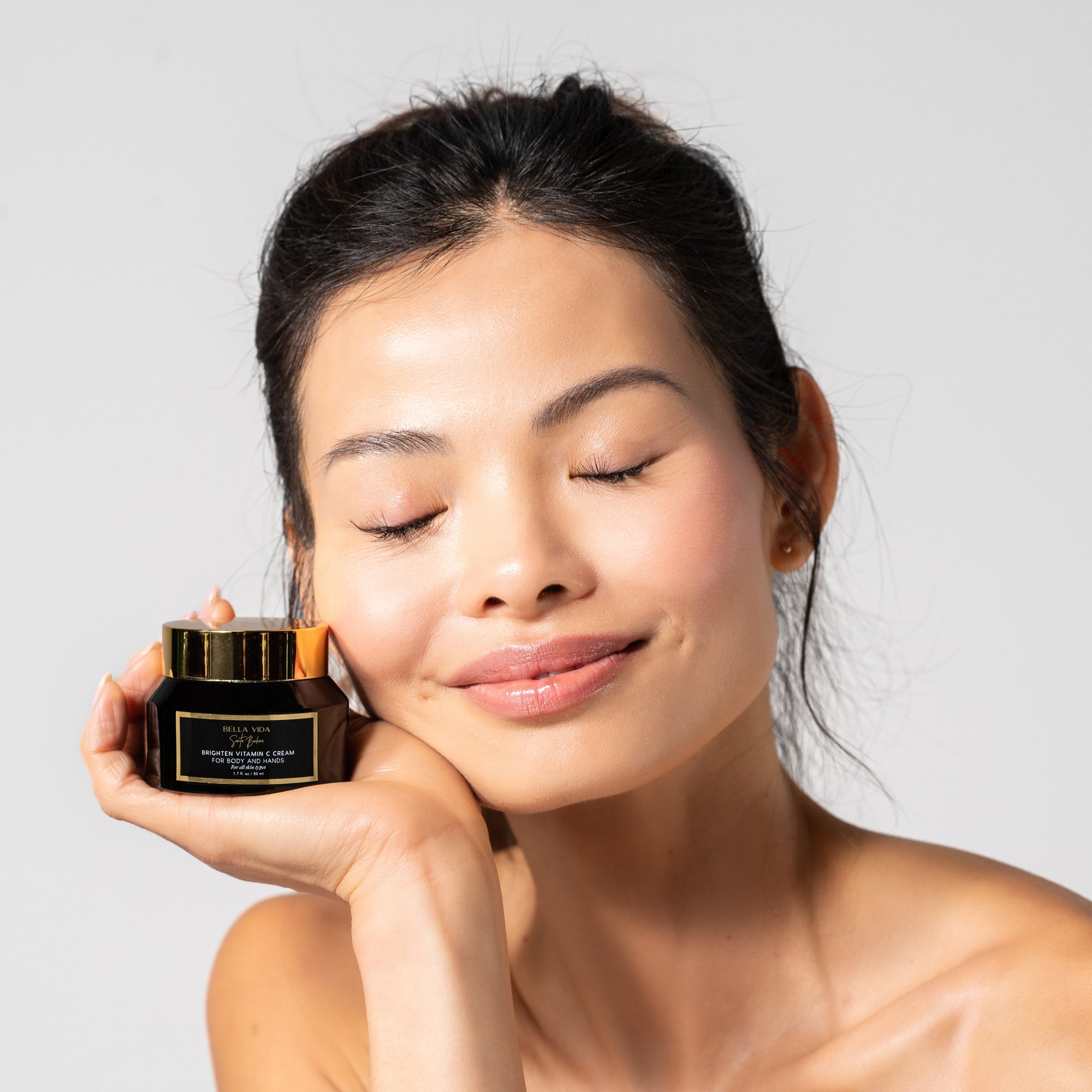 woman holding a jar of Brighten vitamin c cream by Bella Vida Santa Barbara 