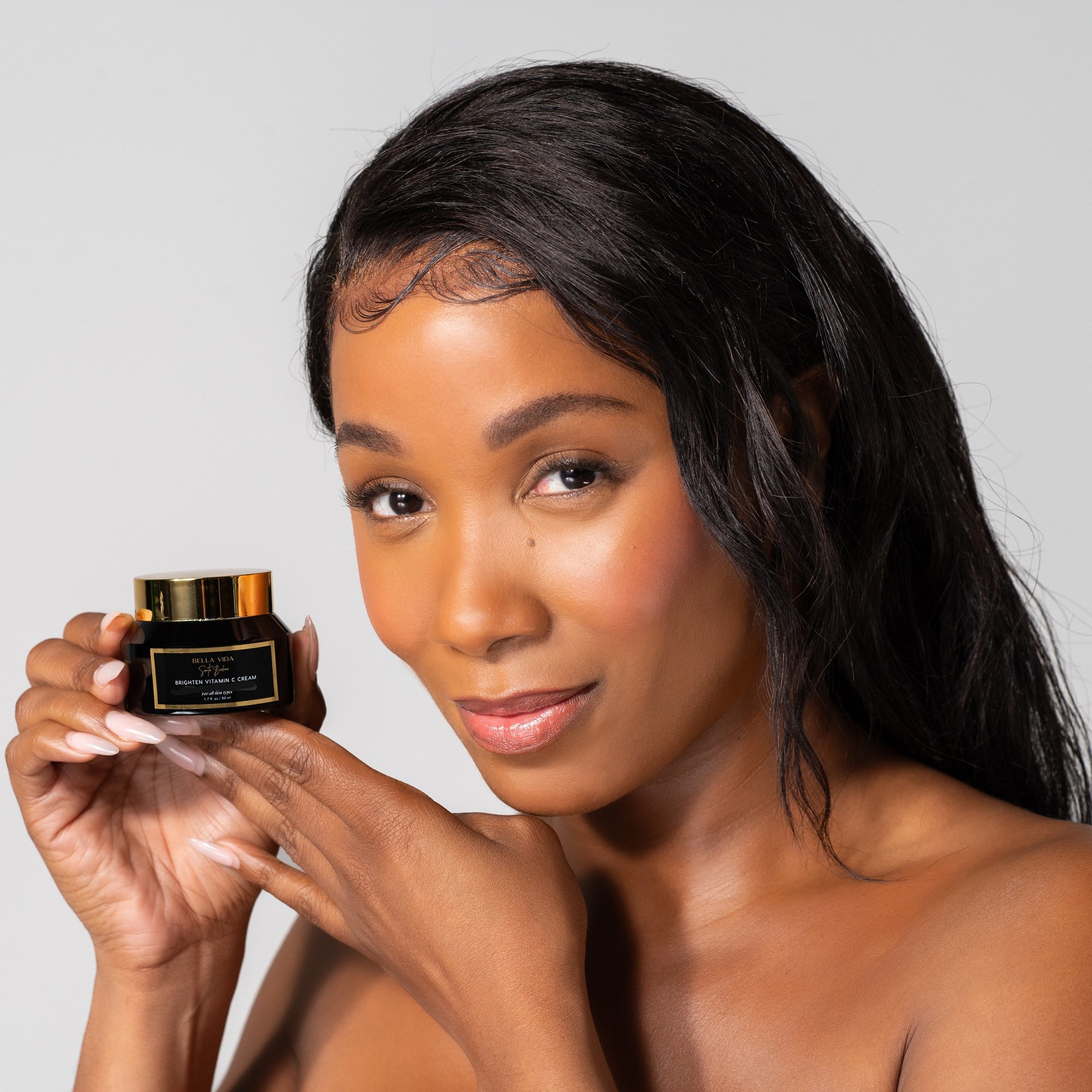 Woman holding A jar of Bella Vida Santa Barbara Brighten Vitamin C Cream with two Beauty Shortlist 2025 and 2024 Award Winner 